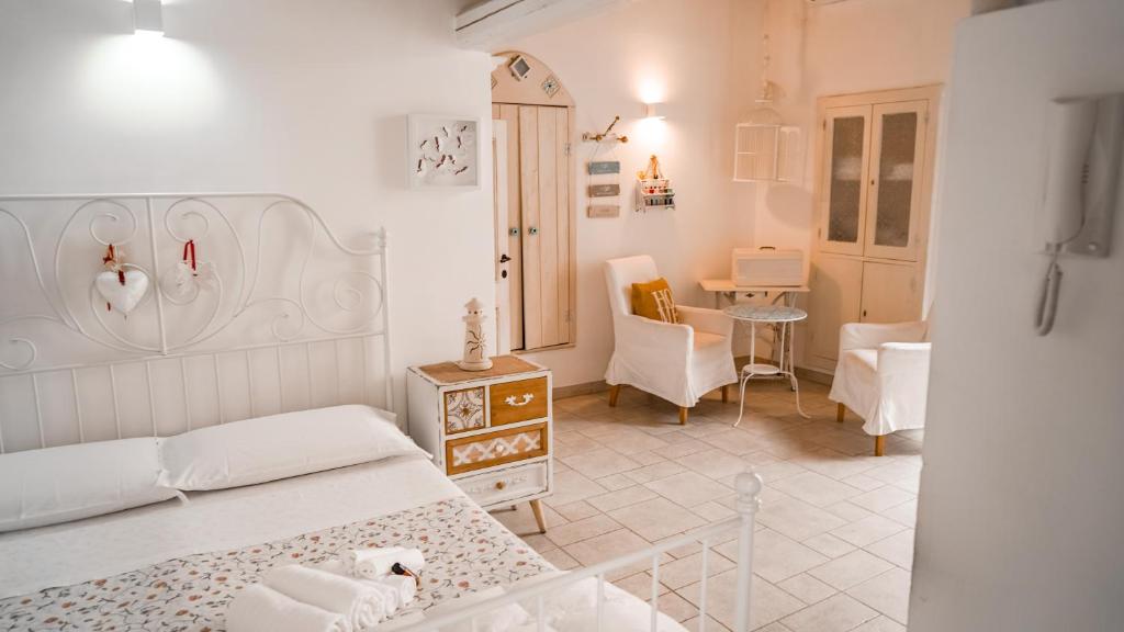 - une chambre avec un lit, une table et des chaises dans l'établissement Karen House B&B, à Polignano a Mare