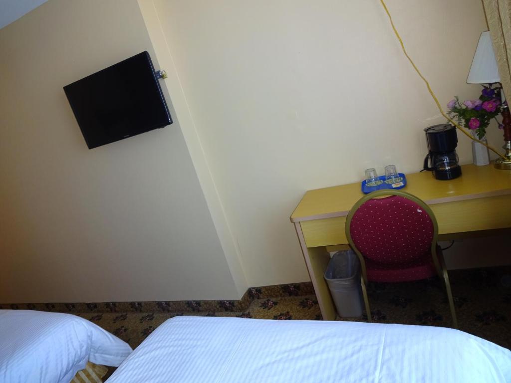 a bedroom with a desk and a bed and a chair at Flushing Hotel in Queens