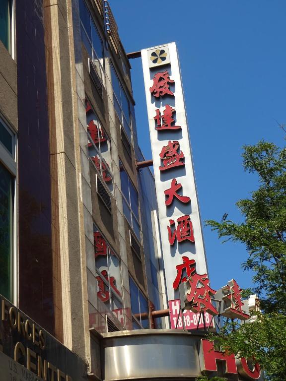a building with chinese signs on the side of it at Flushing Hotel in Queens