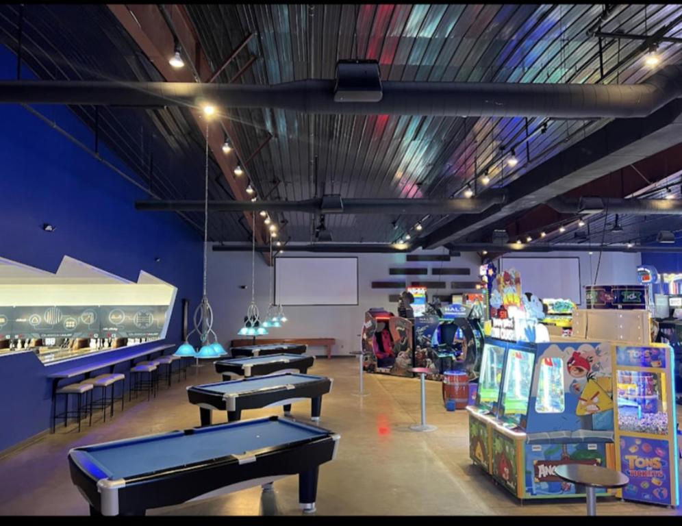 a room with three ping pong tables and some games at Oceanfront Get Away in Myrtle Beach
