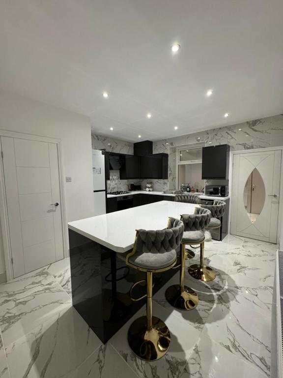 a kitchen with a table and two bar stools at Luxury Travis House in Burnley
