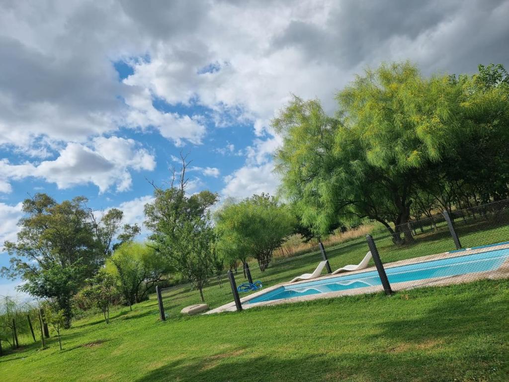 una gran piscina en un parque con árboles en Casa de campo en Zapiola , Lobos, Buenos Aires. en Lobos
