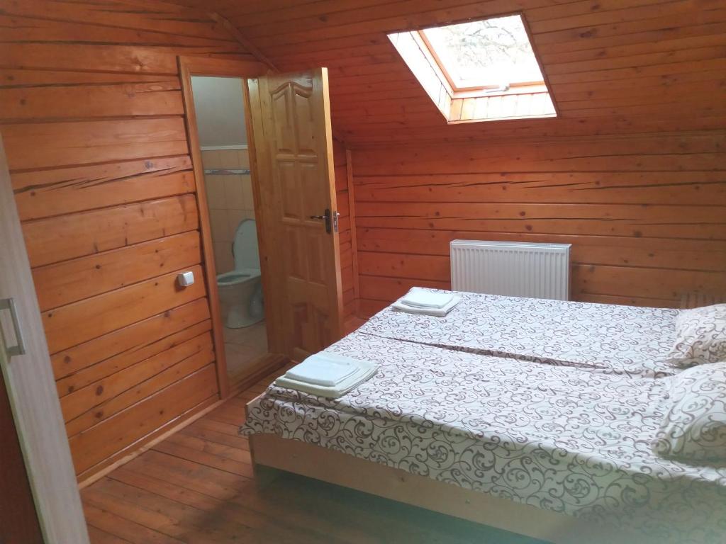 1 dormitorio con 1 cama en una habitación de madera en Зачаровані Карпати, Воловець, en Volovets