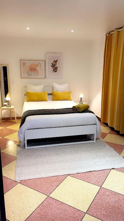 a bedroom with a large bed with yellow pillows at Chambre Olivier in Arles