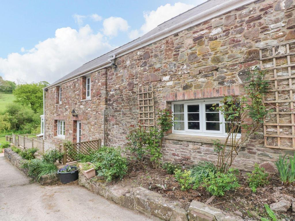 Un edificio de ladrillo con una ventana en el costado. en Corran Cottage, en Carmarthen