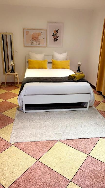 a bedroom with a large bed with yellow pillows at Chambre Olivier in Arles