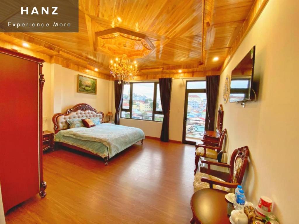 een slaapkamer met een bed en stoelen in een kamer bij HANZ Hoa Dang Hotel in Da Lat