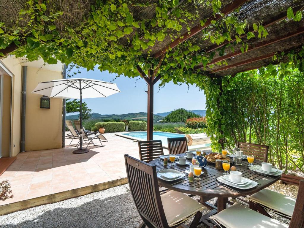 リムーにあるSpacious villa with private swimming poolのパティオ(テーブル、椅子、パラソル付)