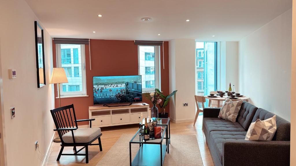 a living room with a couch and a flat screen tv at Shoreditch Apartments by Sleepy in London