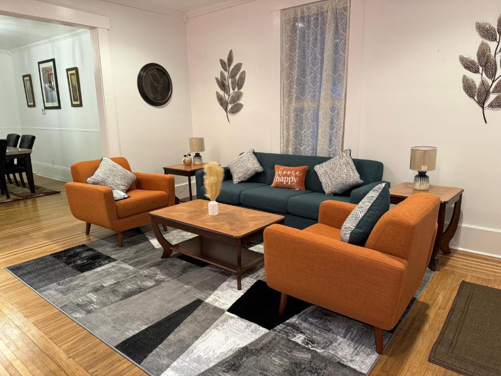 - un salon avec un canapé bleu et des fauteuils orange dans l'établissement Beautiful Bungalow on Main, à Madison