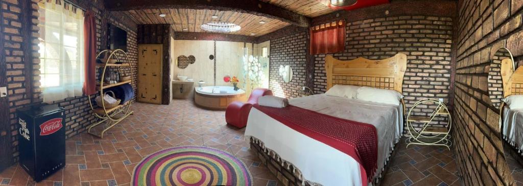 1 dormitorio con 1 cama grande en una habitación con paredes de ladrillo en HOTEL & SPA LOS AGAVES, en Las Ánimas
