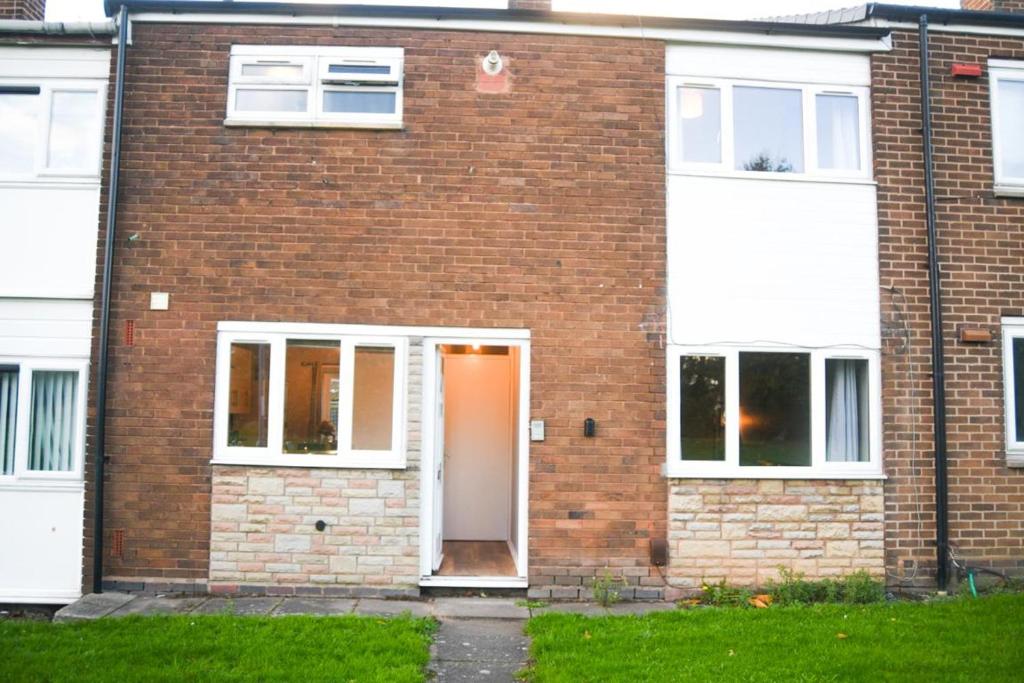 Casa de ladrillo con puerta blanca y ventanas en 2ndHomeStays -Willenhall-Charming 3-Bedroom Home en Walsall