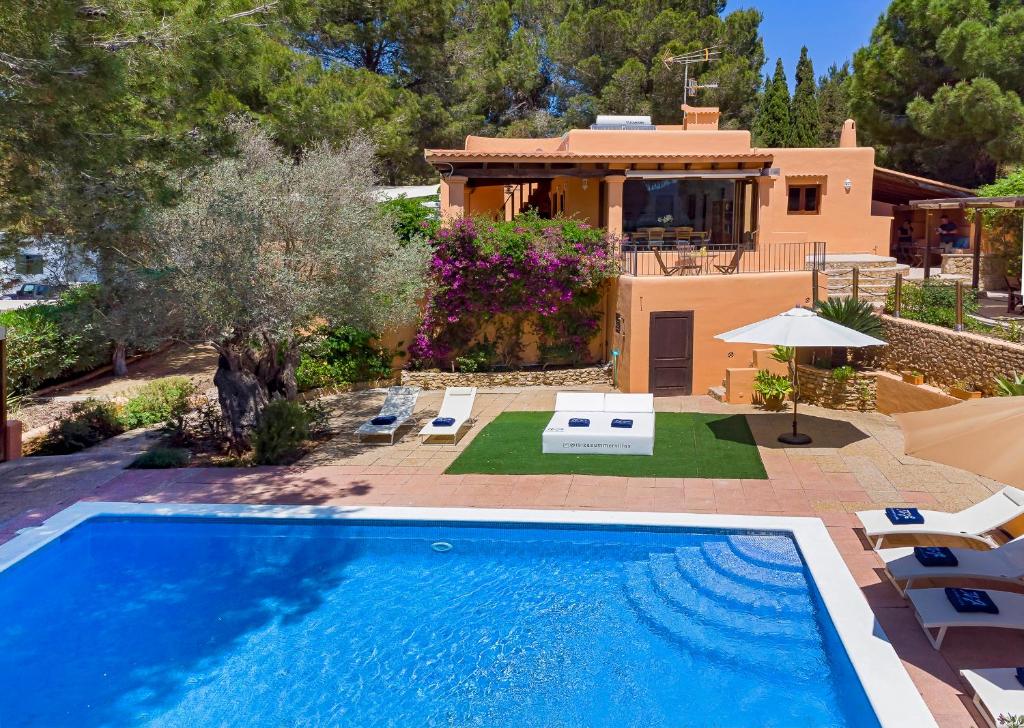 a villa with a swimming pool and a house at Villa in San Rafael Sleeps 12 in Ses Paisses