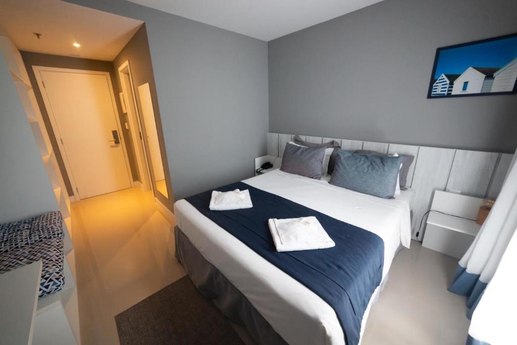 une chambre avec un grand lit avec deux serviettes dessus dans l'établissement Flat 313 na melhor localização de Cabo Frio, à Cabo Frio