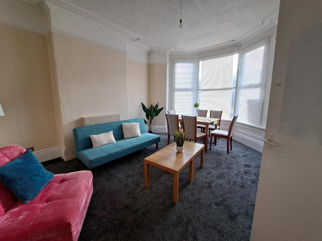 uma sala de estar com um sofá azul e uma mesa em Sheffield city center abode. em Sheffield