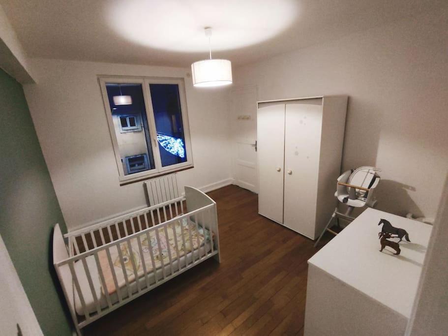 een babykamer met een wieg en een raam bij Appartement spacieux in Charmes