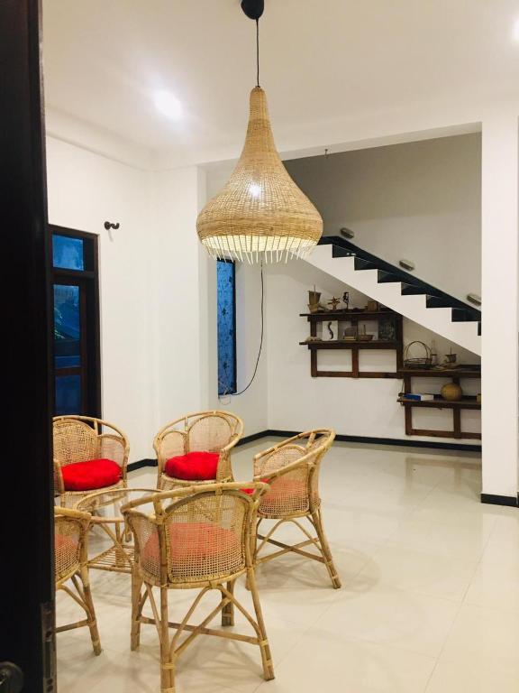 a dining room with a table and chairs and a chandelier at Villa Ocean Breeze in Ahangama
