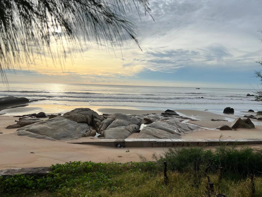 a beach with rocks in the sand and the ocean at Villa biển Oceanami B805 - Ô tô đậu trước cửa nhà in Long Hai