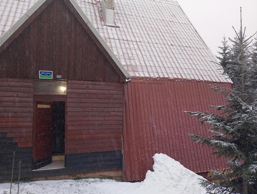 a red building with a red fence in the snow at Goran in Jahorina