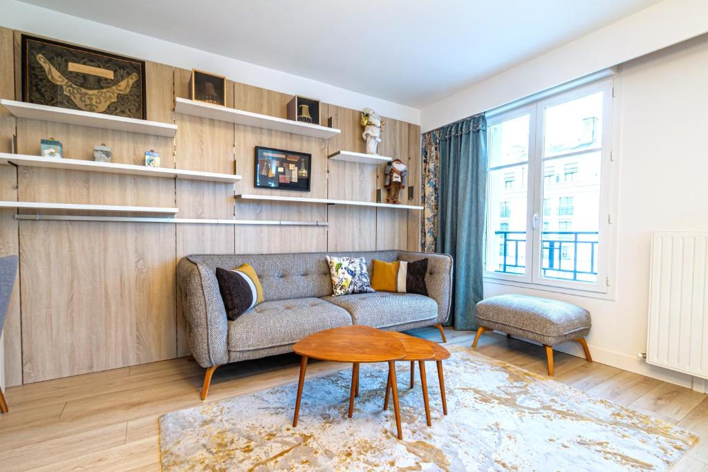 a living room with a couch and a table at Luxueux Appartement Design 70m2 Disneyland Paris pour 6pax in Chessy