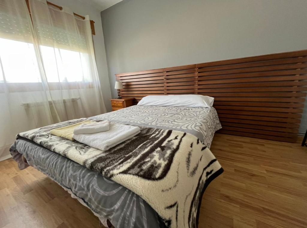 a bedroom with a bed with two towels on it at Pension Matias Rooms in Sarria