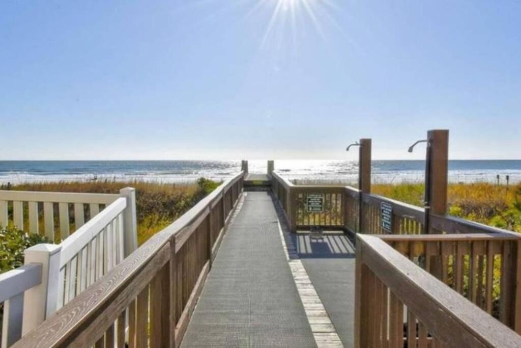 a boardwalk to the beach with the ocean in the background at Oceanfront Get Away in Myrtle Beach