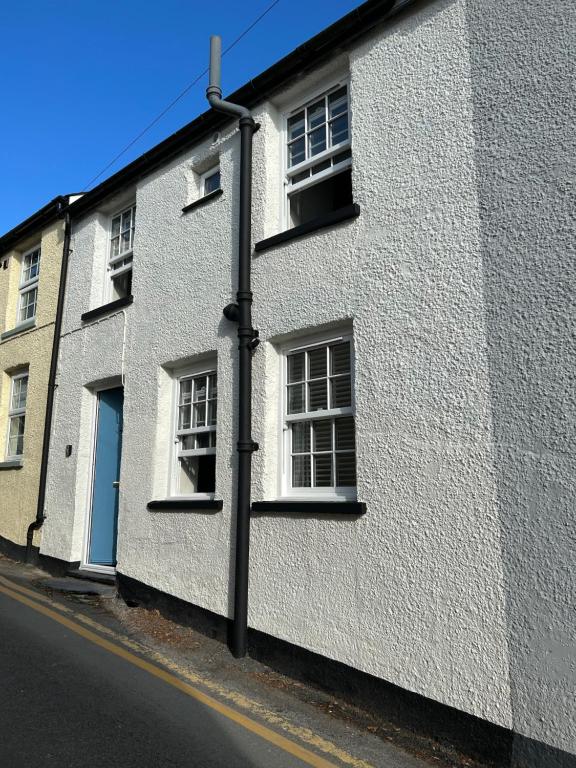 a white building with windows on a street at The Retreat in Aberdyfi