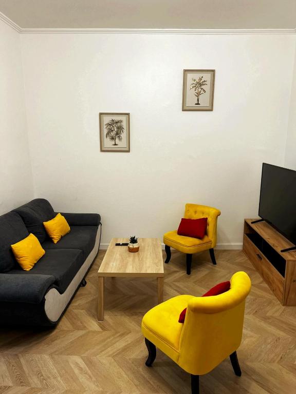 a living room with a couch and a table and chairs at Appartement T2 avec terrasse proche cathédrale in Bourges