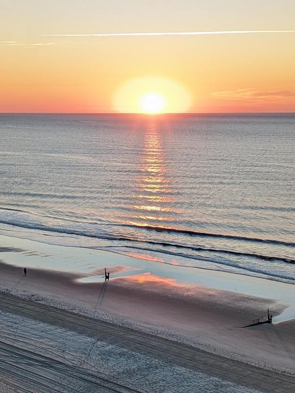 people walking on the beach at the sunset at Oceanfront Get Away in Myrtle Beach