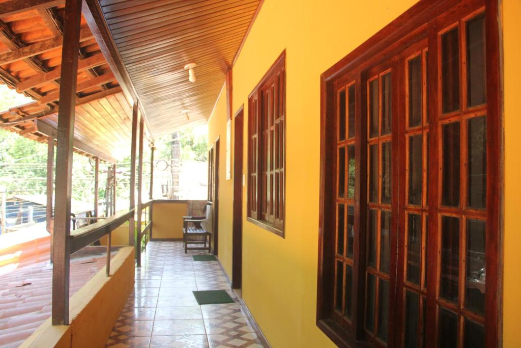 a hallway of a house with yellow walls and windows at Lonier Villa Inn Economic in Abraão