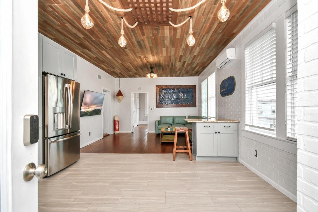 a kitchen with a wooden ceiling and a refrigerator at Nautical Loft with Outdoor Kitchen & Beach Access in Galveston