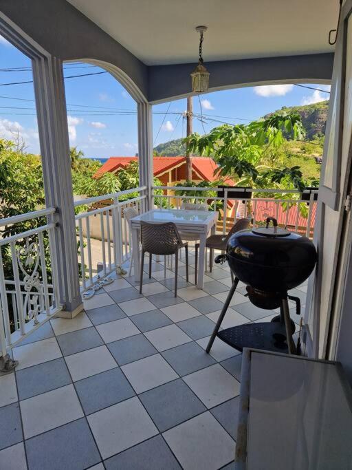 a screened in porch with a table and a grill at La maison du Pêcheur in Terre-de-Haut