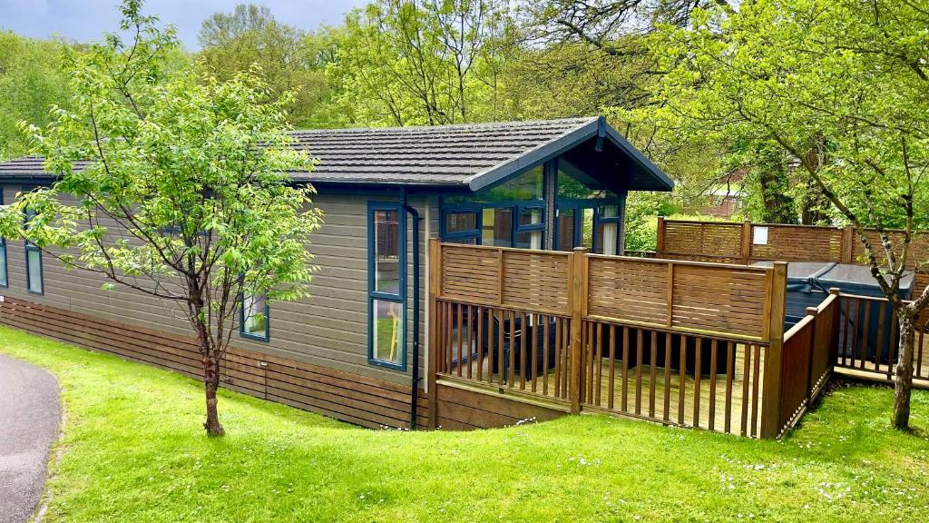 a house with a wooden deck and a yard at Beautiful Oak Cabin in Devon Finlake Resort Spa in Chudleigh
