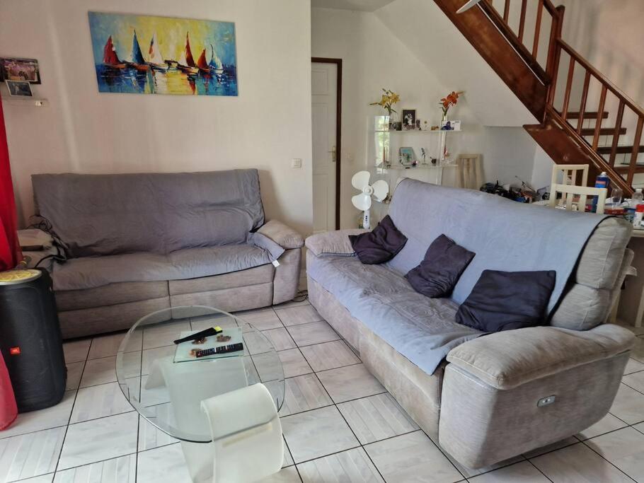 a living room with a couch and a glass table at La maison du Pêcheur in Terre-de-Haut