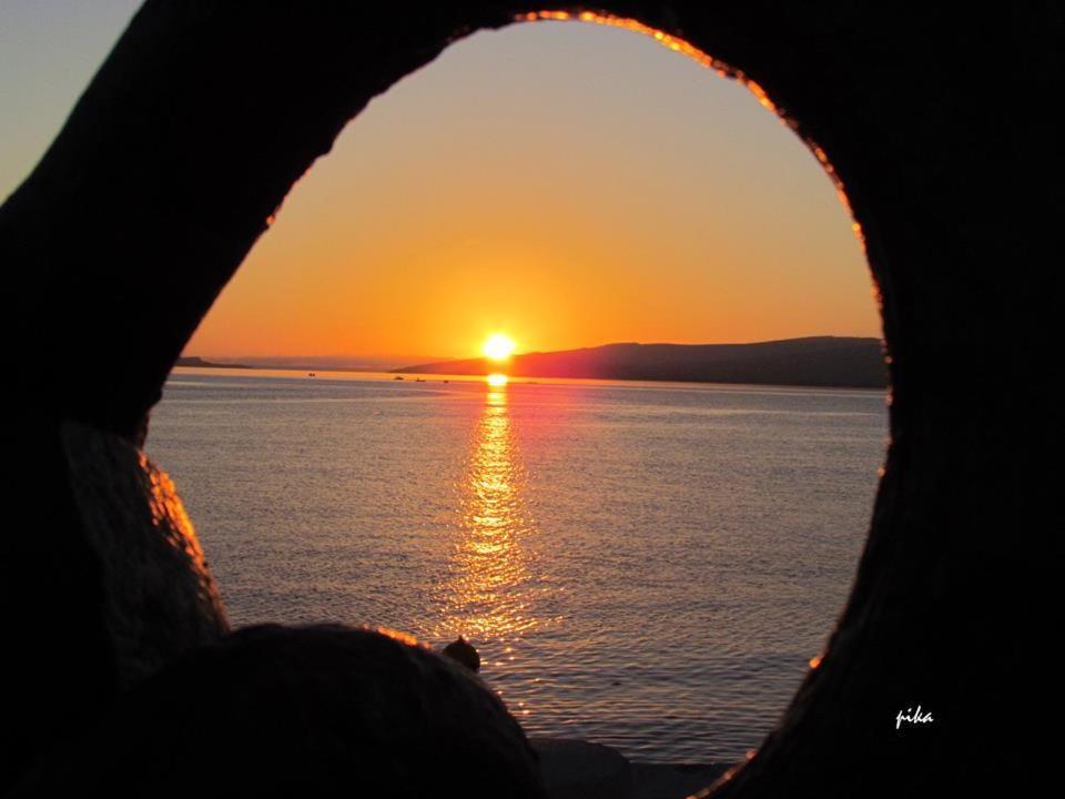 a view of the sunset through a hole in a wheel at Karlo1 Apartment in Senj
