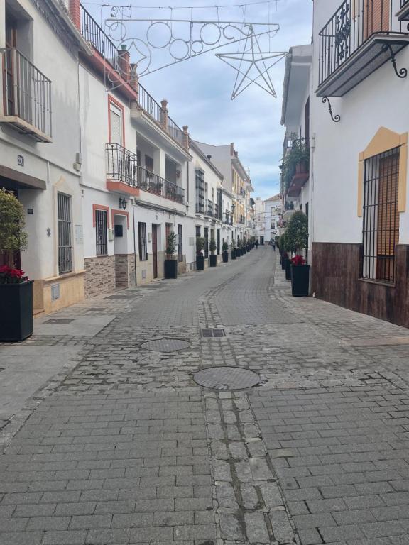 an empty street in a town with white buildings at Casa Sol y Luna in Alozaina