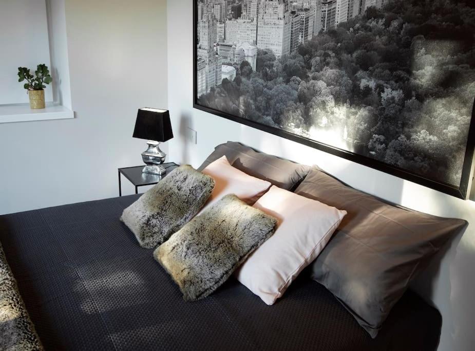 1 cama con 2 almohadas y una foto en la pared en Appartamento NEW YORK, en Torre dʼIsola