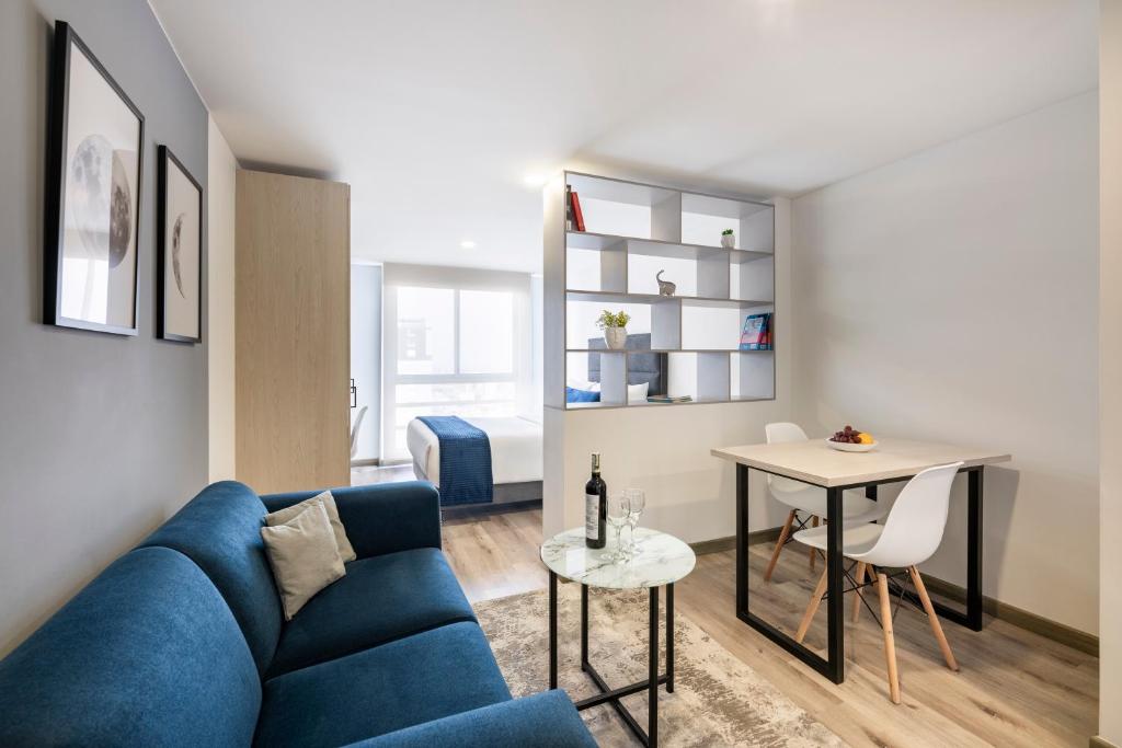 a living room with a blue couch and a table at Torre Ventto Lofts in Bogotá