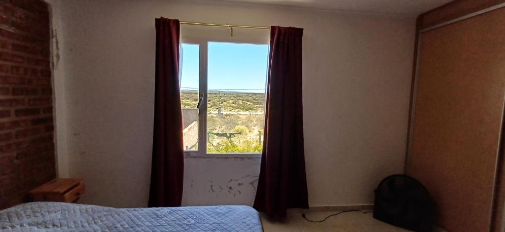 1 dormitorio con cama y ventana con vistas en Vientos Del Salado en Playas Doradas