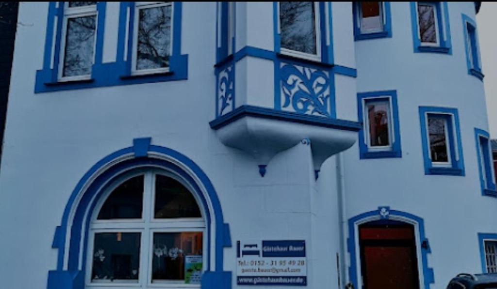 een blauw-wit gebouw met een raam en een deur bij Ferienwohnung Gästehaus Bauer in Heiligenhaus