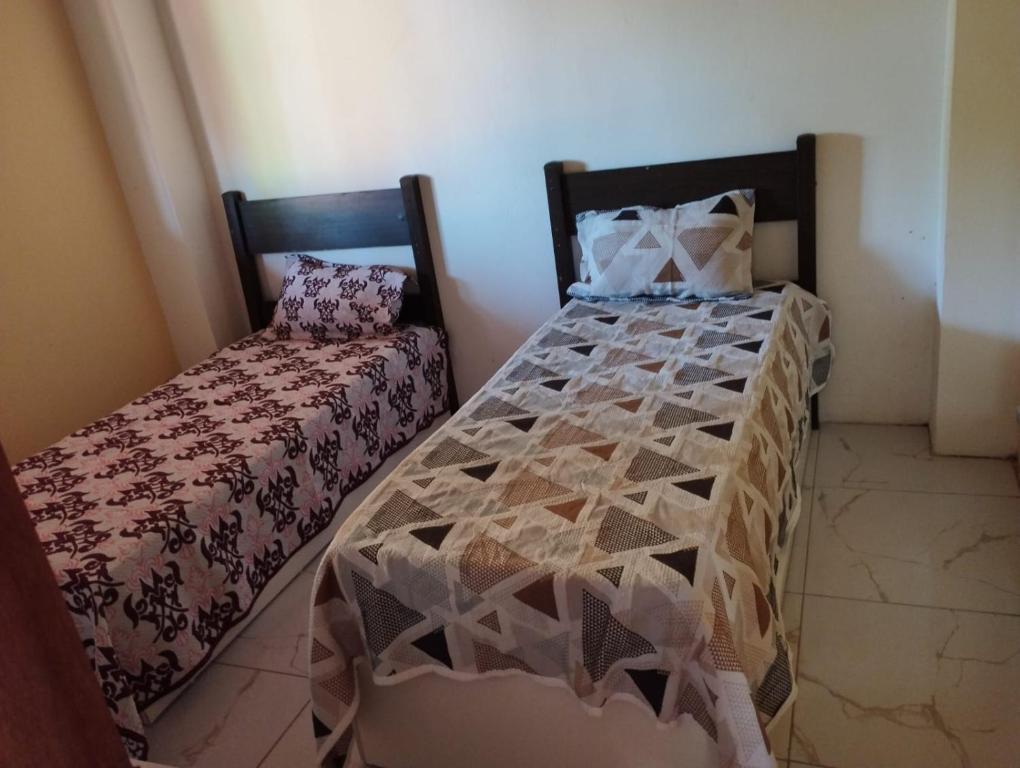 ein kleines Schlafzimmer mit einem Bett und einem Stuhl in der Unterkunft Paraíso da Deise in Mata de Sao Joao