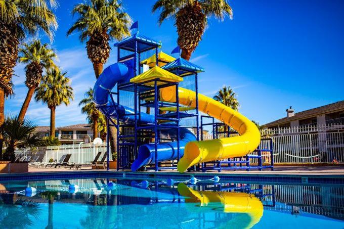 a blue and yellow water slide in a swimming pool at 19| Vue at Green Valley with Community Pool in St. George
