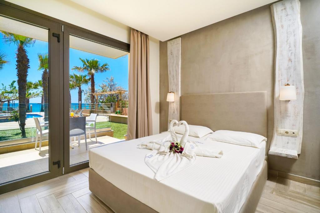 a bedroom with a white bed with a view of the ocean at Blue view Hotel in Limenaria