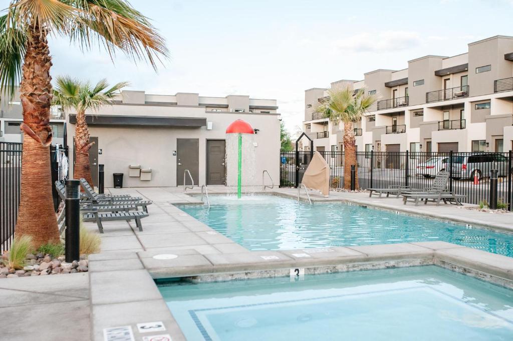 a swimming pool with palm trees and buildings at 20| Vue at Green Valley with Community Pool in St. George