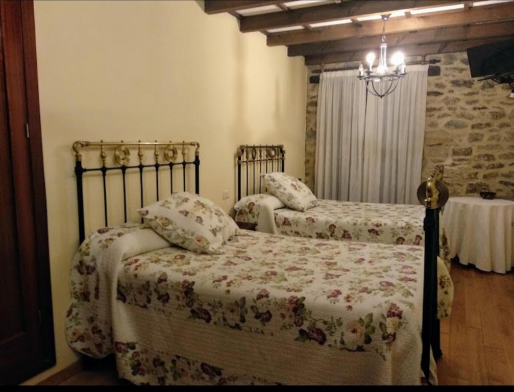 1 dormitorio con 2 camas y mesa en Pazo de San Lorenzo en Puebla de Trives