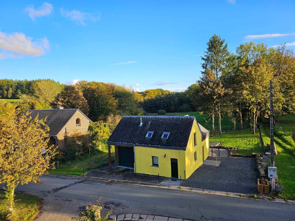 eine Aussicht auf ein gelbes Haus auf einer Straße in der Unterkunft Gite de caractère rural in Bastogne