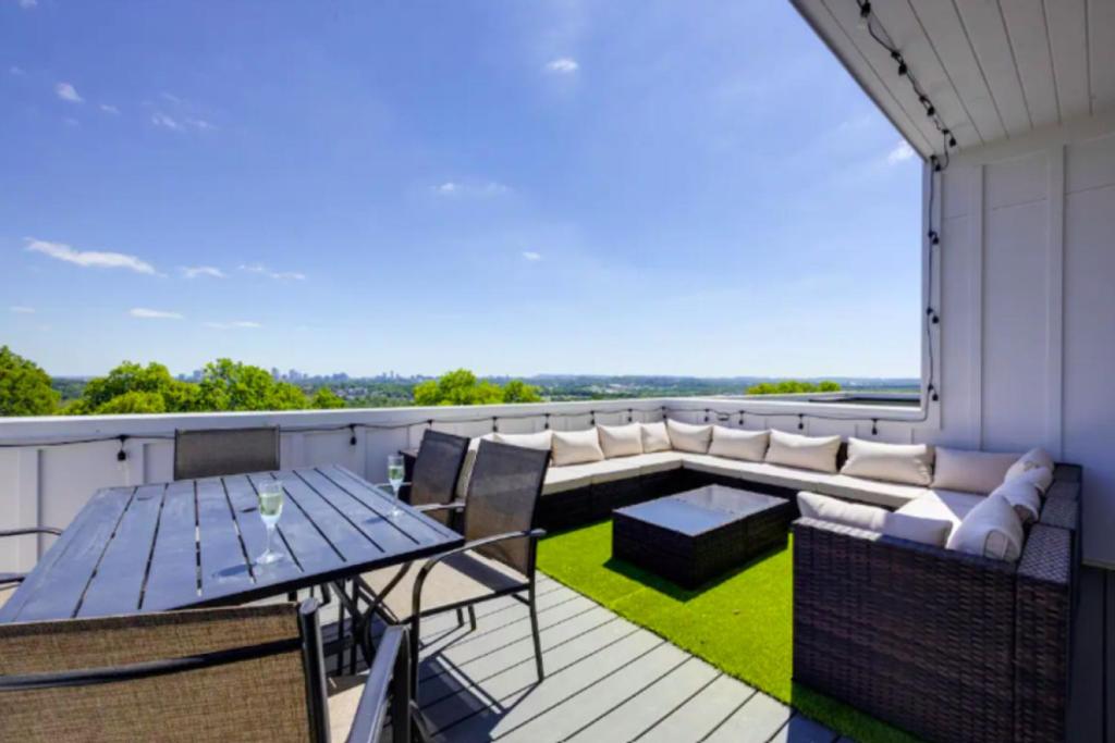 a patio with a table and chairs on a balcony at Luxury four-story Home with Rooftop views, 10min to Downtown! Sleeps 12! in Nashville