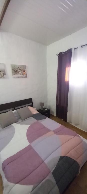 1 dormitorio con 1 cama grande con una manta colorida en Casa de María del Pilar, en Taibique