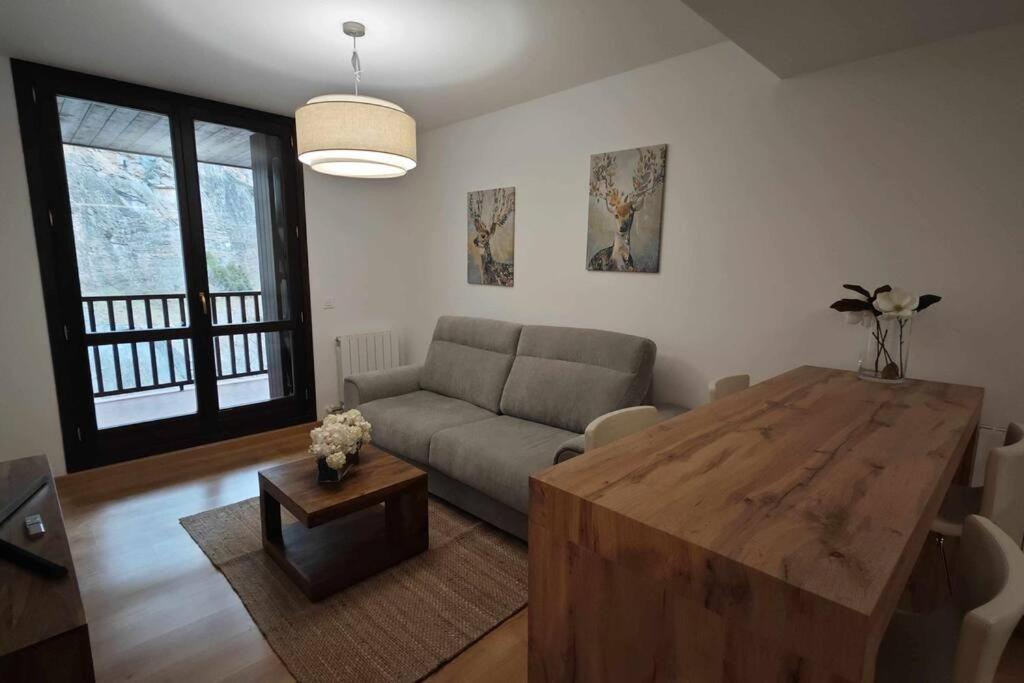 エスカリリャにあるMimosa 4 con terraza - tucasaenlospirineosのリビングルーム(ソファ、木製テーブル付)