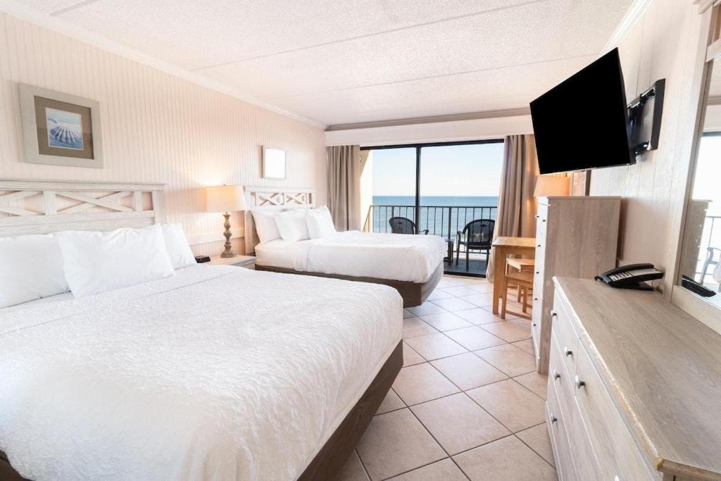 um quarto de hotel com duas camas e uma televisão de ecrã plano em Beach Bliss Haven, OF Tower Room 6th Floor em Pawleys Island